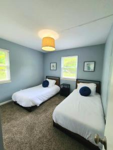 2 camas en una habitación con paredes azules en Urban Excitement Suburban Calm Hot Tub & Game Room, en Louisville