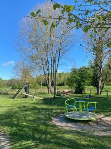 einen Park mit einer Bank und einem Tisch im Gras in der Unterkunft Le Chalet avec jacuzzi privatif in Nargis