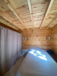 Bett in einem Holzzimmer mit Holzdecke in der Unterkunft Le Chalet avec jacuzzi privatif in Nargis