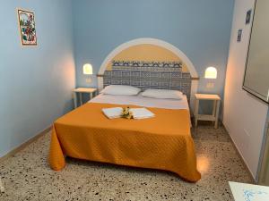 - une chambre avec un lit doté d'un couvre-lit orange dans l'établissement Bed & Breakfast Sole Azzurro, à Custonaci