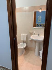 La salle de bains est pourvue d'un lavabo et de toilettes. dans l'établissement Bed & Breakfast Sole Azzurro, à Custonaci