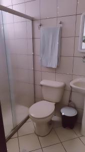 a white bathroom with a toilet and a sink at Hotel Rio Branco in Jequié