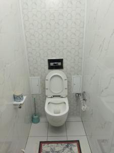 - une salle de bains blanche avec toilettes dans une cabine dans l'établissement Квартира в новом районе, à Öskemen