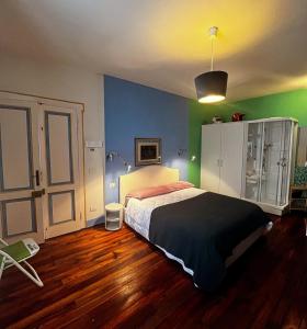 a bedroom with a bed and green and blue walls at RL - Boutique Suites & Apartments in Bienno