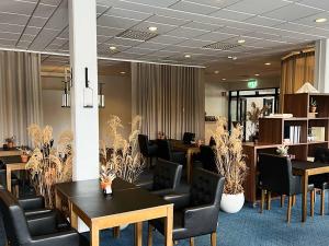a meeting room with tables and chairs and plants at Ronneby Brunn in Ronneby