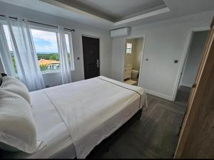 a bedroom with a large bed and a large window at LUXE MORDERN RESIDENTIAL LIVING INC. in Lance aux Épines