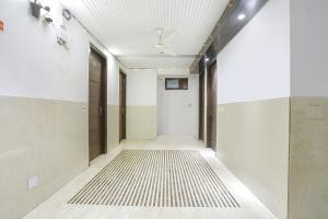 pasillo con paredes blancas y alfombra blanca y negra en FabExpress Lotus Palace, en Nueva Delhi