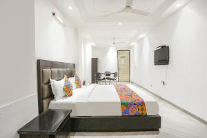 um quarto de hotel com uma cama e uma televisão em FabExpress Lotus Palace em Nova Deli