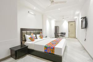 um quarto com uma cama, uma mesa e cadeiras em FabExpress Lotus Palace em Nova Deli