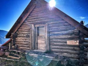 an old log cabin with the sun on the roof at Les 3 Flocons Roure in Roure