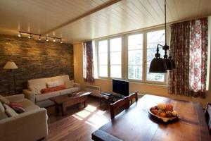 ein Wohnzimmer mit einem Sofa und einem Tisch in der Unterkunft Apartamento con jardín - Montana Park in Enveitg