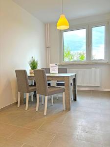 d'une salle à manger avec une table, des chaises et une fenêtre. dans l'établissement Hammerhotel Apartments Halle Saale, à Halle-sur-Saale