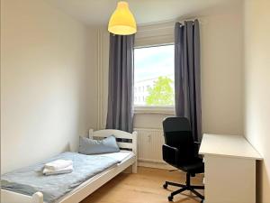 a bedroom with a bed and a desk and a window at Hammerhotel Apartments Halle Saale in Halle an der Saale