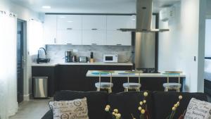 a kitchen with a couch and a kitchen with white cabinets at LUXE MORDERN RESIDENTIAL LIVING INC. in Lance aux Épines