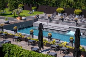 a swimming pool with tables and chairs next to a pool at Hotel & Wellness Zuiver in Amsterdam