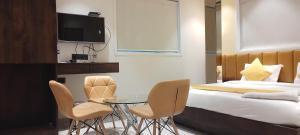 pokój hotelowy z łóżkiem, stołem i krzesłami w obiekcie Shine Hospitality Group w Bombaju