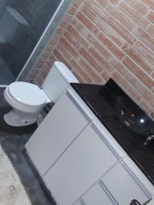 a bathroom with a white toilet and a sink at Chalé PERTO DO CÉU em Gramado in Gramado