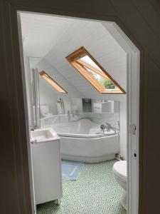 ein weißes Bad mit einer Badewanne und einem WC in der Unterkunft Villa Julia Marie in Saint-Valéry-en-Caux