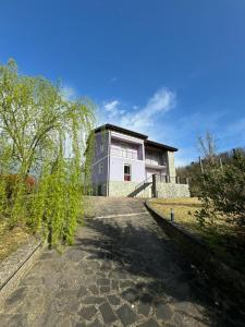 une maison sur une colline avec un arbre devant elle dans l'établissement Villa Lilla 2, à Fivizzano