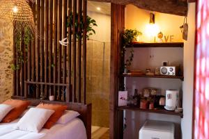 a bedroom with a bed with white sheets and orange pillows at Mas de l'Amme in Valréas