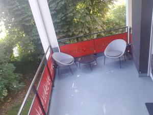 a balcony with three chairs and a red railing at Appartement 2 chambres avec terrasse et garage in Saint-André-lez-Lille