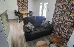 - un salon avec un canapé en cuir noir et des oreillers dans l'établissement Amazing Home In Saint-gervais-en-belin With Kitchen, à Saint-Gervais en-Belin