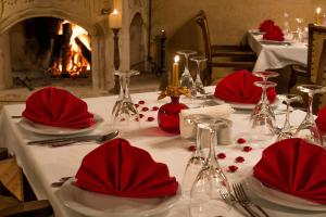 una mesa con servilletas rojas y copas de vino. en Hotel Temenni Evi, en Ürgüp