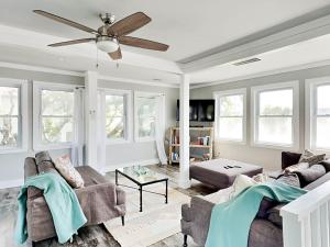 a living room with two couches and a ceiling fan at Boho Beach House in Tybee Island