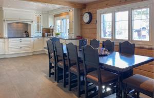 una cucina con tavolo, sedie e orologio di 4 Bedroom Awesome Home In Bjorli a Bjorli