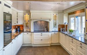 una cucina con armadi bianchi e una grande isola di 4 Bedroom Awesome Home In Bjorli a Bjorli