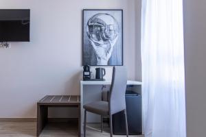 un escritorio con una silla y una foto de un casco de fútbol en MAMA GUEST HOUSE, en Ciampino