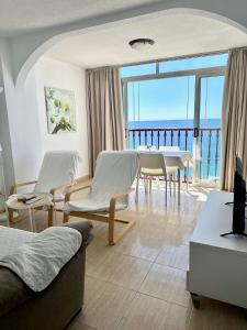 una sala de estar con muebles blancos y vistas al océano. en Las Damas - Aloturin Benidorm, en Benidorm