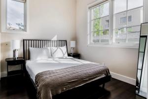 a bedroom with a large bed with two windows at Blueground Burlingame wd ac near dining SFO-1688 in Burlingame