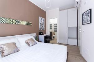 Schlafzimmer mit einem weißen Bett und einem Schreibtisch in der Unterkunft MAMA GUEST HOUSE in Ciampino