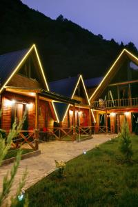a log cabin with lights on it at night at KOZLUCA Bungalov in Trabzon