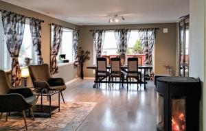 sala de estar con chimenea, mesa y sillas en Beautiful Apartment In Hellvik With House Sea View, en Hellvik