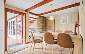 ヴィデ・サンデにあるBeautiful Home In Hvide Sande With 3 Bedrooms, Sauna And Wifiのダイニングルーム(木製テーブル、椅子付)