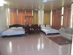 a bedroom with two beds and a table and chairs at Excelsior Sylhet Hotel & Resort in Sylhet
