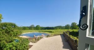 a view of a swimming pool from a window at Manor Farm House in Bristol