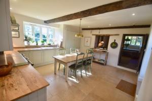 cocina con mesa de madera y sillas en Manor Farm House en Bristol