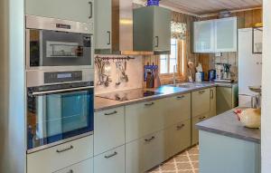 uma cozinha com armários brancos e electrodomésticos de aço inoxidável em 4 Bedroom Gorgeous Home In Bjorli em Bjorli