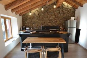 een keuken met een aanrecht met 2 stoelen en een tafel bij Skyfall Maison in Valcebollère