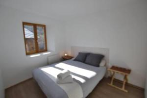 een slaapkamer met een bed met een spiegel en een raam bij Skyfall Maison in Valcebollère