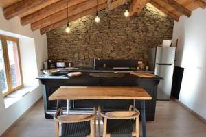 een keuken met een tafel en 2 stoelen. bij Skyfall Maison in Valcebollère +4 foto's