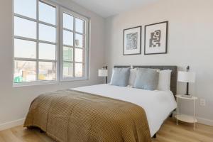 a white bedroom with a large bed and two windows at Dumbo 2br w wd roof gym nr TimeOut Building NYC-957 in Brooklyn