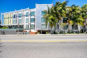 una calle vacía frente a un edificio con palmeras en Blueground Mid-Wilshire pool nr food shops LAX-1210, en Los Ángeles