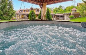 a pool of water in a yard with a house at Gorgeous Home In Radovanci With Jacuzzi 