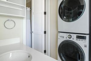 a white laundry room with a washer and dryer at Blueground Burlingame wd ac near Caltrain SFO-1687 in Burlingame