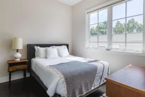 a white bedroom with a bed and a window at Blueground Burlingame wd ac near Caltrain SFO-1687 in Burlingame