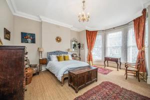 a bedroom with a bed and a chandelier at Pass the Keys Exquisite Flat - Ten minutes to Central London in London